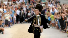 Seorang anak berlari memasukkan tombak kedalam lubang sasaran selama turnamen tradisional Alka di desa Vuckovici, Kroasia, Minggu (23/8/2015). Turnamen ini memperingati kemenangan Kroasia atas pemerintahan Turki Ottoman. (REUTERS/Antonio Bronic) 