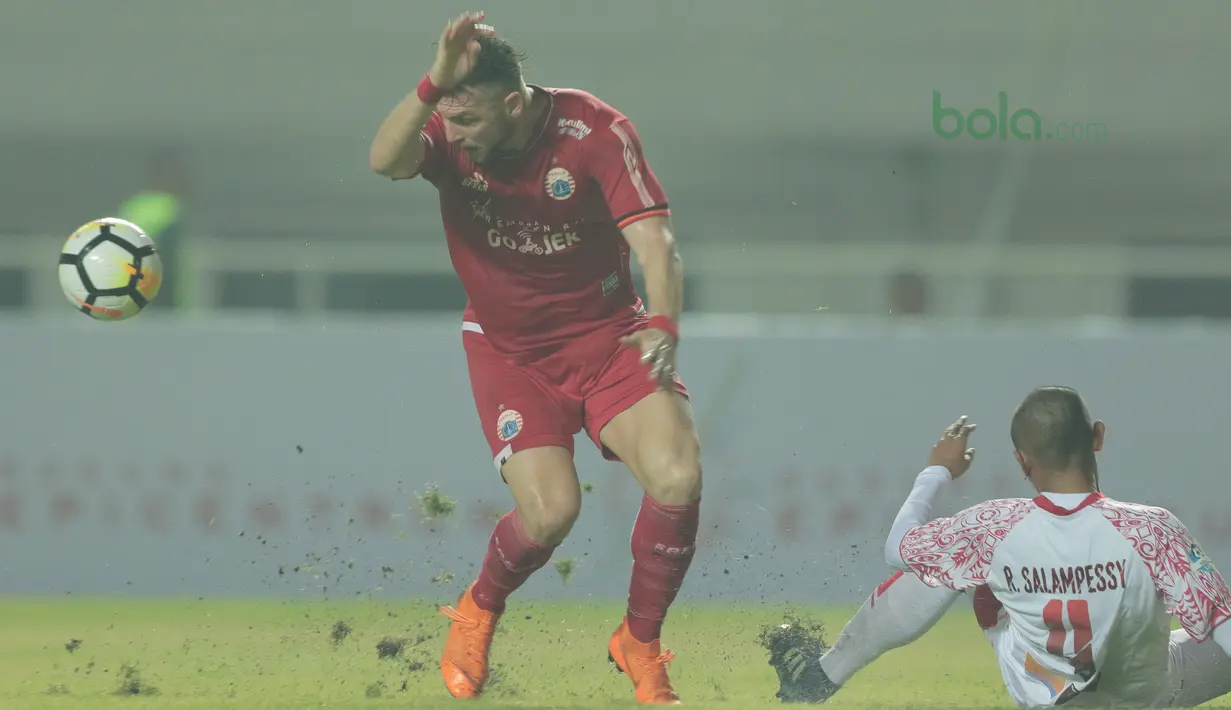 Duel pemain Persija Jakarta, Marko Simic dengan pemain Persipura Jayapura, Ricardo Salampessy pada lanjutan Liga 1 Gojek bersama Bukalapak di Stadion Pakansari, Bogor, (25/5/2018).  Persija menang 2-0. (Bola.com/Nick Hanoatubun)