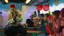 Anak-anak Suriah yang terlantar bernyanyi di sebuah bus yang diubah menjadi ruang kelas di dekat desa Hazano di Suriah barat laut (15/9/2019). Sejak proyek itu diluncurkan pada Mei, sekitar 1.000 anak telah mendapat manfaat dari program kelas bus ini. (AFP Photo/Aaref Watad)