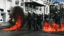 Sejumlah polisi anti huru-hara melawan aksi demonstran yang melemparkan bom api di Athena, Yunani, (12/11/2015). Para Demonstran memprotes langkah-langkah penghematan yang diminta oleh badan pinjaman internasional. (REUTERS/Alkis Konstantinidis)