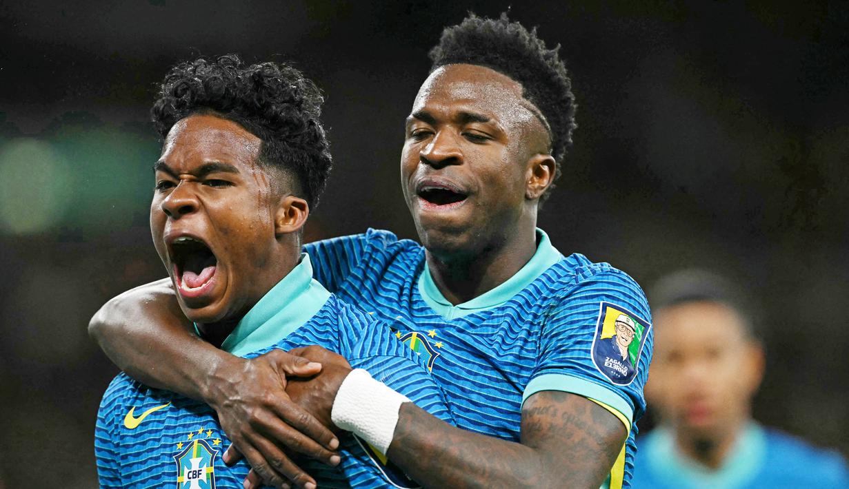 Pemain Brasil, Endrick, melakukan selebrasi bersama Vinicius Jr setelah mencetak gol ke gawang Inggris dalam laga persahabatan di Stadion Wembley, Minggu (24/3/2024). Talenta muda Brasil ini akan memperkuat Real Madrid di usia 18 nanti. (AFP/Glyn Kirk)