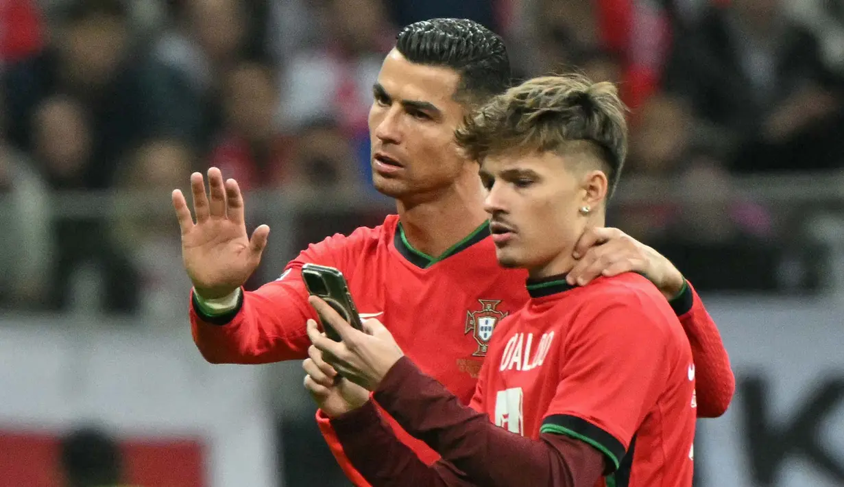 Cristiano Ronaldo sempat menyetop tindakan steward yang hendak mengusir suporter yang menginvasi lapangan. (Sergei GAPON/AFP)