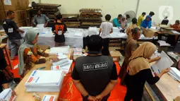 Anggota Bawaslu Tangerang Selatan mengawasi langsung pekerja yang melipat surat suara di gudang logistik. (merdeka.com/Arie Basuki)