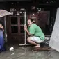 Warga berada di depan rumah saat banjir merendam permukiman Bukit Duri, Jakarta, Kamis (18/2/2021). Hujan deras yang mengguyur sejak pagi menyebabkan permukiman warga di 5 RW, yakni RW 03, 04, 05, 06, dan 07 Kelurahan Bukit Duri terendam banjir. (merdeka.com/Iqbal S Nugroho)