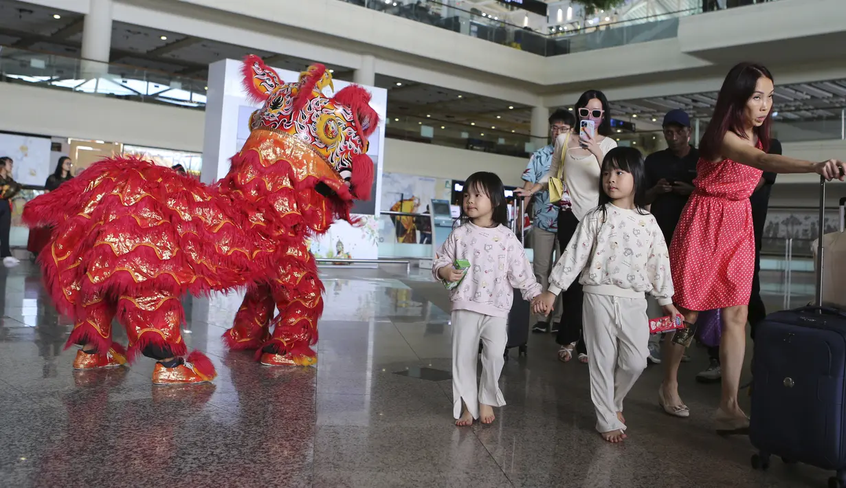 <p>Penari barongsai menyambut wisatawan mancanegara (wisman) asal China yang tiba di bandara internasional Ngurah Rai di Bali, Minggu (22/1/2023). Penerbangan langsung turis China ke Bali dengan penerbangan maskapai Lion Air dari Shenzhen yang membawa sebanyak 210 pax. (AP Photo/Firdia Lisnawati)</p>