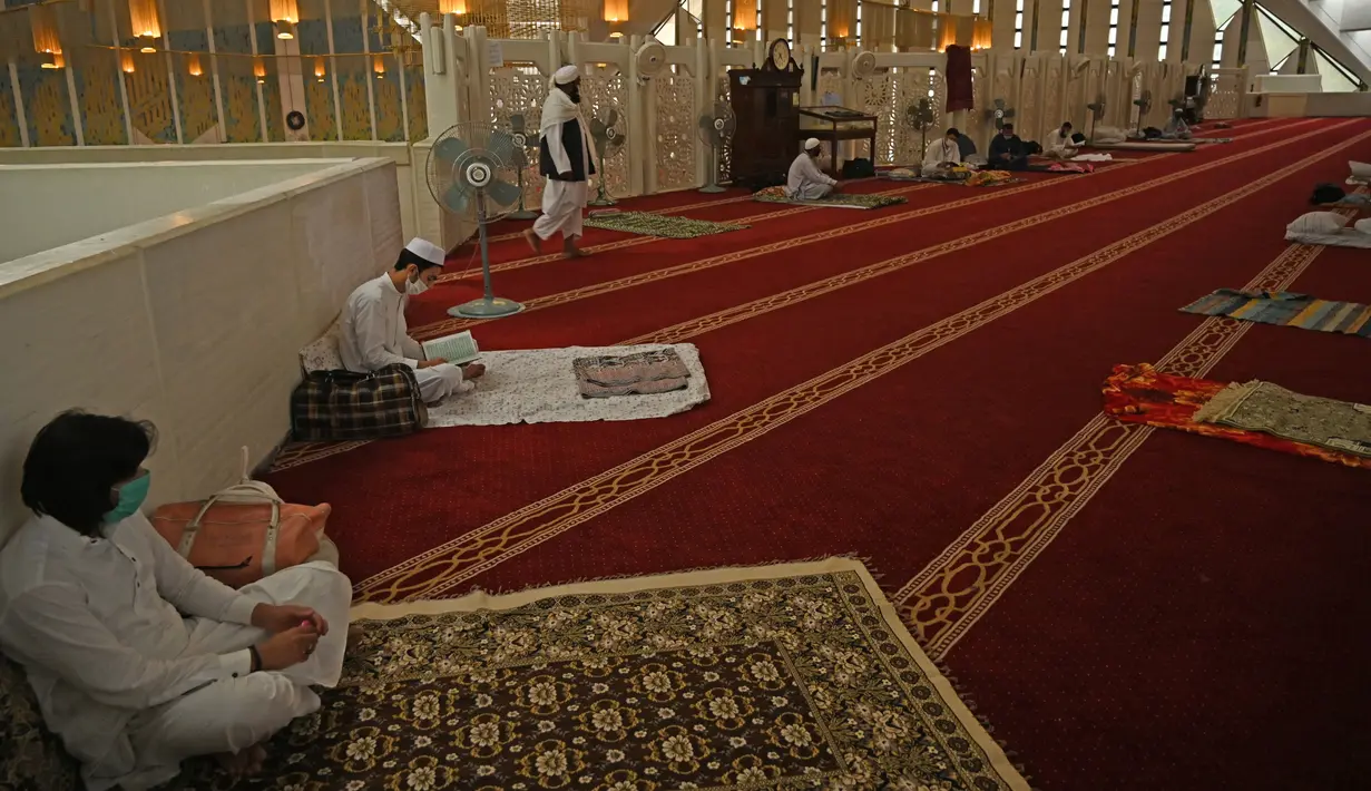 Pria Muslim (kedua kiri) membaca Alquran saat beritikaf di Masjid Agung Faisal di Islamabad, Pakistan, Kamis (14/5/2020). Itikaf adalah berdiam diri di masjid dengan niat beribadah untuk mendekatkan diri kepada Allah swt pada sepuluh hari terakhir bulan Ramadan. (Aamir QURESHI/AFP)