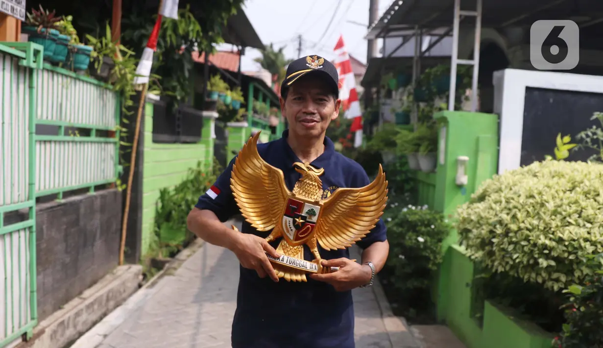 Warga membawa patung burung garuda pancasila di Kampung Pancasila, Karang Tengah, Kota Tangerang, Selasa (1/6/2021). Sejumlah kegiatan diadakan warga, Komunitas Taman Potret dan TNI ini untuk memperingati Hari kelahiran Pancasila. (Liputan6.com/Angga Yuniar)