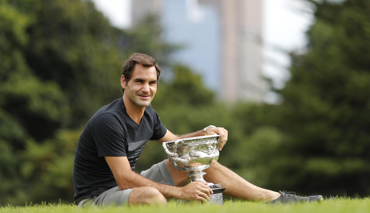 Petenis Swiss, Roger Federer melakukan sesi foto dengan Trofi Norman Brookes Challenge pada Australia Terbuka 2018 di Melbourne, Australia,(29/1/2018). (AP/Ng Han Guan)