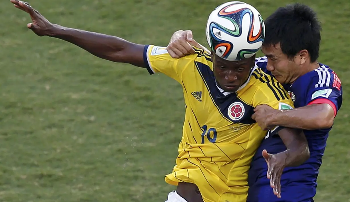 Pemain belakang Jepang, Yasuyuki Konno (kanan) berusaha menahan penyerang Kolombia, Adrian Ramos, saat berlaga di penyisihan Piala Dunia Grup C di Stadion Pantanal, Cuiaba, Brasil, (25/6/2014). (REUTERS/Suhaib Salem)