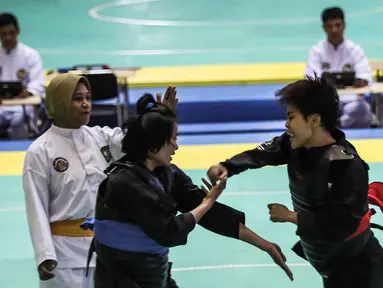 Pesilat Nirmalasari Oktaviani (kanan) beradu jurus dengan pesilat Laos Olathai Sounthavong di semifinal 50-55 kg putri cabang Pencak Silat 18th Asian Games Invitation Tournament, Jakarta, Senin (12/2). Indonesia menang 5-0. (Liputan6.com/Faizal Fanani)