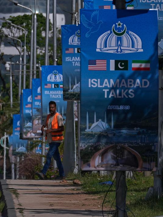 Sebelumnya, pada perundingan pertama yang dilaksanakan di Islamabad, Pakistan, pada 11-12 April 2026, berakhir tanpa kesepakatan. Tampak dalam foto, seorang pekerja berjalan melewati papan reklame menjelang putaran kedua negosiasi antara Amerika Serikat dan Iran, di Islamabad, Pakistan, Senin 20 April 2026. (AP Photo/Anjum Naveed)