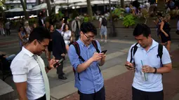 Sejumlah pria asyik bermain augmented reality Pokemon Go di Bryant Park, New York City, Amerika Serikat, 11 Juli 2016. Sejak dirilis, game keluaran Nintendo dan The Pokemon Company itu berhasil menjadi candu para penggunanya. (REUTERS/Mark Kauzlarich)