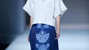 Seorang model berjalan diatas catwalk mengenakan busana rancangan desainer Xuefei Sun saat China Fashion Week di Beijing, Tiongkok (30/10). Motif fauna Cina yang paling popular adalah motif burung hong (phoenix), naga, kura-kura,ikan mas. (AFP/STR)