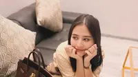 Potret lain memperlihatkan Prilly tampil chic dengan padu padan striped long shirt warna brick, loose pants warna beige, dan tas Hermes Birkin B35 bordeaux togo leather with gold hardware seharga Rp329 jutaan. [@prillylatuconsina96]