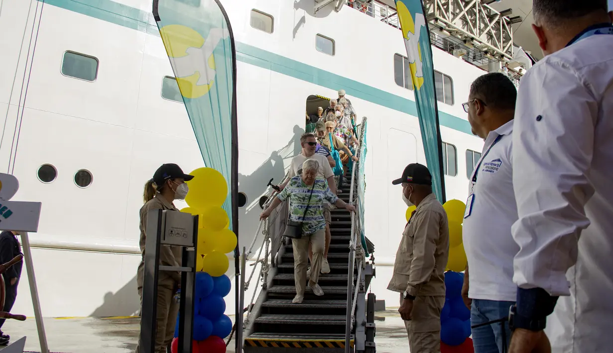 Turis dari berbagai negara dari negara-negara Eropa datang ke darat dari kapal pesiar MS Amadea di pelabuhan El Guamache di Isla Margarita, negara bagian Nueva Esparta, Venezuela (3/1/2023). Kapal pesiar Jerman MS Amadea adalah yang pertama tiba di Venezuela Pulau Karibia setelah 15 tahun. (AFP/Gustavo Granado)