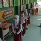 Sejumlah murid menerapkan jaga jarak sebelum masuk ke sekolah di SD Negeri 6, Bekasi, Jawa Barat, Selasa (4/8/2020). Pemerintah setempat memberikan izin kepada enam sekolah untuk melakukan uji coba pembelajaran tatap muka selama satu bulan. (Liputan6.com/Herman Zakharia)