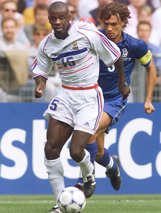 Bek Italia, Paolo Maldini mengejar bola yang dibawa bek Prancis Lilian Thuram pada perempatfinal Piala Dunia 1998 di Stade de France di Saint-Denis. AC Milan mengumumkan Maldini lewat situs resminya pada Minggu (5/8/2018). (AFP Photo/Gabriel Bouys)