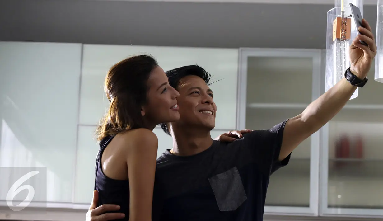 Ariel Noah dan seorang model bernama Nina Kozok tampak berselfie pada syuting video klip 'Cinta Bukan Dusta' di Depok, Jawa Barat, Rabu (18/11/2015). Lagu tersebut merupakan bagian dari album untuk mengenang Rinto Harahap. (Liputan6.com/Herman Zakharia)