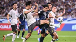 Pemain Jepang, Takumi Minamino (tengah) berebut bola dengan sejumlah pemain China pada laga putaran ketiga Grup C Kualifikasi Piala Dunia 2026 yang berlangsung di Saitama Stadium, Saitama, Jepang, Kamis (05/09/2024) WIB. (AFP/Yuichi Yamazaki)