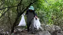 Ini berbahaya karena area bakau adalah nursery ground (tempat pembiakan) bagi ikan dan kepiting yang nantinya akan dikonsumsi. Tampak dalam foto, warga membersihkan sampah plastik di area hutan bakau sebagai bagian dari kampanye kebersihan di Desa Serangan, Denpasar, Bali, pada Rabu 15 April 2026. (SONNY TUMBELAKA/AFP)