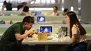 Pengunjung menikmati makanan mereka di restoran Robot.He milik Alibaba di Shanghai, 30 Juli 2018. Restoran ini mengganti para pelayan dengan sejumlah robot pintar sebesar oven microwave untuk menerima pesanan dan mengantarkan makanan. (AFP)