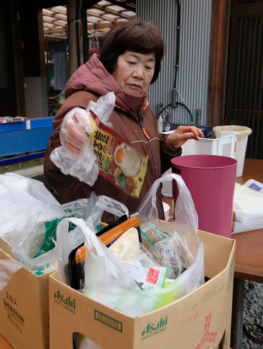 Seorang warga bernama Saeko Takahashi memisahkan sampah ke dalam kotak-kotak yang berbeda di dapur rumahnya di kota Kamikatsu, Prefektur Tokushima, 14 Maret 2019. Penduduk kota di barat daya Jepang ini memiliki visi menjadi tempat tanpa limbah pada 2020 mendatang. (Kazuhiro NOGI/AFP)