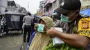 Petugas polisi memasangkan masker kepada warga saat kabut asap tebal menyelimuti wilayah Banda Aceh (25/9/2019). Kebakaran hutan Indonesia menyebabkan hampir 10 juta anak dalam risiko pencemaran udara. (AFP Photo/Chaideer Mahyuddin)