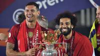 Pemain Liverpool Mohamed Salah (kanan) dan Dejan Lovren mengangkat trofi Liga Inggris usai bertanding melawan Chelsea di Anfield Stadium, Liverpool, Inggris, Rabu (22/7/2020). Penyerahan trofi Liga Inggris kepada Liverpool digelar tanpa penonton karena pandemi COVID-19. (Paul Ellis, Pool via AP)