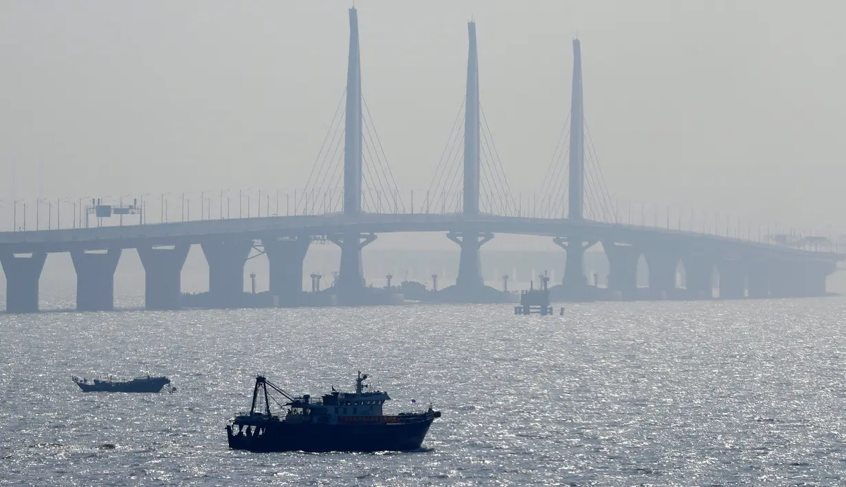 Sebuah perahu berlayar dekat jembatan Hong Kong-Zhuhai-Macau di kota Zhuhai, China selatan, Rabu (28/3). Jembatan laut terpanjang di dunia itu menghubungkan Hong Kong, Macau, dan Zhuhai—tiga kota terpenting dan makmur di China. (AP Photo/Kin Cheung)