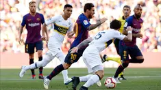Penyerang Barcelona, Lionel Messi menggiring bola dari kejaran pemain Boca Juniors selama pertandingan Piala Joan Gamper di stadion Camp Nou, Spanyol (15/8). Barcelona menang telak 3-0 atas Boca Juniors. (AP Photo/Manu Fernandez)