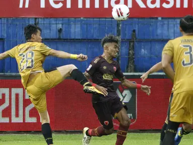 Pemain PSM Makassar Yakob Sayuri (tengah) dijaga dua pemain Bhayangkara Solo FC, Hansamu Yama (kanan) dan Alsan Sanda dalam pertandingan matchday ke-2 Babak Penyisihan Grup B Piala Menpora 2021 di Stadion Kanjuruhan, Malang, Sabtu (27/3/2021). Kedua tim bermain imbang 1-1. (Bola.com/Ikhwan Yanuar)
