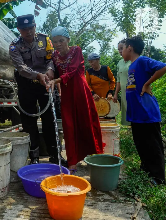 <p>Anggota polisi dari Polsek Jonggol membantu pendistribusian air bersih kepada warga. (merdeka.com/Arie Basuki)</p>
