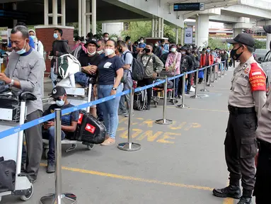 Polisi berjaga saat calon penumpang mengntre untuk rapid test antigen di Terminal 2 Bandara Soekarno-Hatta, Tangerang, Banten, Selasa (22/12/2020). Calon penumpang mengaku rata-rata antre hingga tiga jam untuk mendapatkan layanan rapid test antigen. (merdeka.com/Arie Basuki)