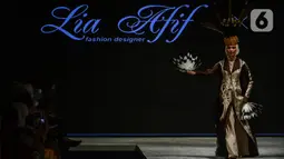 Model mengenakan busana kain rancangan karya LIA AFIF fashion desainer berkolaborasi dengan Pemkab Kutai Timur pada Indonesia Fashion Week 2022 di Jakarta Convention Center, Rabu (13/4/2022). Perhelatan Indonesia Fashion Week mengangkat tema "Magnificient Borneo". (Liputan6.com/JohanTallo)