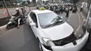 Pengendara sepeda motor tersendat saat melintasi lokasi kecelakaan taksi menabrak tiang di Jalan Ahmad Yani, Jakarta, Rabu (1/8). Tidak ada korban jiwa dalam kecelakaan tersebut. (Merdeka.com/Iqbal Nugroho)