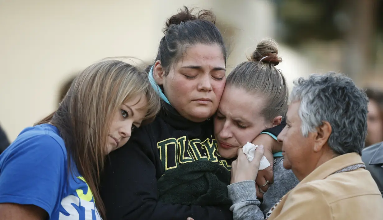 Sejumlah wanita menangis saat melakukan aksi simpatik mengenang korban penembakan di Kampus Umpqua Community College di Roseburg, Sabtu (3/10/2015). Setidaknya 15 orang tewas dalam peristiwa tersebut. (REUTERS / Lucy Nicholson)