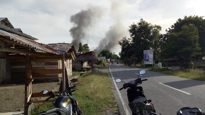 Kepulan asap tebal, diduga akibat terbakarnya sekolah ketika pecah bentrok antar warga Desa Hualoy dan Desa Lattu, Rabu 20 Februari 2019. (Abdul Karim/ Liputan6.com)