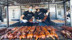 Para koki berpose bersama iga bakar olahan mereka dalam acara drive-thru Scarborough Ribfest 2020 di Toronto, Kanada, pada 27 September 2020. Pengunjung festival makanan yang digelar dalam format drive-thru itu dapat memesan makanan dari penjual di lokasi dan membawanya pulang. (Xinhua/Zou Zheng)