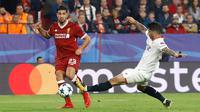 Pemain Sevilla, Ever Banega dan pemain Liverpool, Emre Can berebut bola pada laga kelima Grup E Liga Champions di Stadion Ramon Sanchez Pizjuan, Rabu (22/11). Sempat unggul tiga gol, Liverpool kemudian justru diimbangi Sevilla 3-3. (AP/Miguel Morenatti)