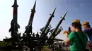 Anak-anak difoto oleh ibunya diatas rudal di Memorial "Stalin Line", dekat Desa Goroshki, Belarusia, (10/9). Selain pertunjukan pertempuran, di tempat ini juga banyak memamerkan alat-alat tempur Perang Dunia II. (Reuters/Vasily Fedosenko)