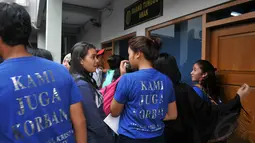 Beberapa dari siswa SMA 3 memakai baju bertuliskan 'kami juga korban' sebagai bentuk protes atas disidangkannya keempat rekan mereka, Jakarta, (26/8/14). (Liputan6.com/Johan Tallo)