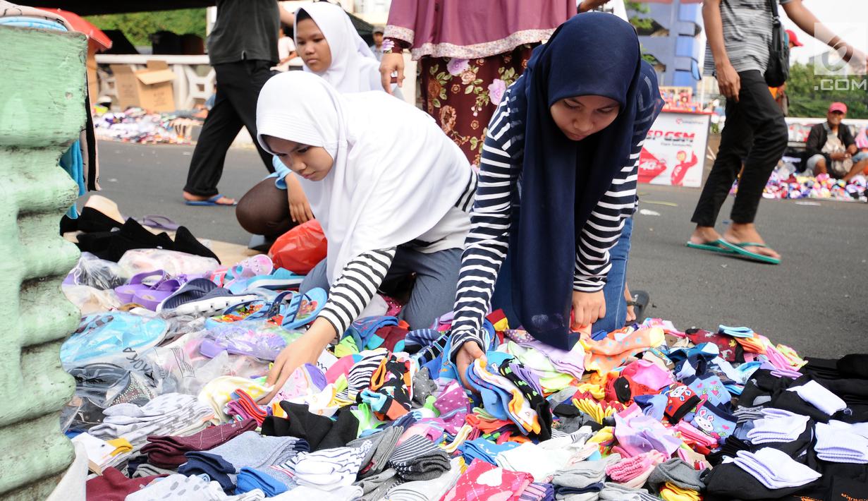 Warga memilih kaus kaki yang dijajakan pedagang di sekitar Pasar Asemka, Jakarta, Rabu (5/7). Jelang bergantinya tahun ajaran baru, sejumlah warga berburu peralatan sekolah di kawasan Pasar Asemka Jakarta. (Liputan6.com/Helmi Fithriansyah)