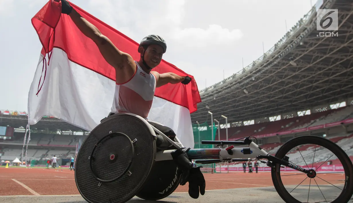 Pebalap kursi roda Indonesia, Jaenal Aripin, berselebrasi usai meraih medali perak Asian Para Games pada cabang atletik nomor balap kursi roda 200 meter T 54 di SUGBK, Jumat (12/10). Jaenal mencatatkan waktu 26,21 detik. (Bola.com/Vitalis Yogi Trisna)