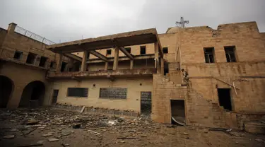 Seorang tentara Irak memeriksa Gereja St. George Monastery (Mar Guguis) yang rusak parah di Mosul, 22 Januari 2017. Salah satu gereja bersejarah di Irak tersebut tak luput dari pengerusakan yang dilakukan kelompok radikal ISIS. (AHMAD AL-RUBAYE/AFP)