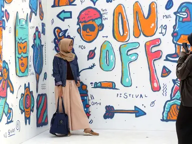 Pengunjung berfoto di salah satu stand karya seni komtemporer yang dipamerkan digelaran ON/OFF Festival di Istora Gelora Bung Karno, Jakarta, Sabtu (7/9/2019). Gelaran ON/OFF Festival akan berlangsung hingga Minggu (8/9). (Liputan6.com/Helmi Fithriansyah)