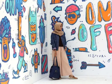 Pengunjung berfoto di salah satu stand karya seni komtemporer yang dipamerkan digelaran ON/OFF Festival di Istora Gelora Bung Karno, Jakarta, Sabtu (7/9/2019). Gelaran ON/OFF Festival akan berlangsung hingga Minggu (8/9). (Liputan6.com/Helmi Fithriansyah)