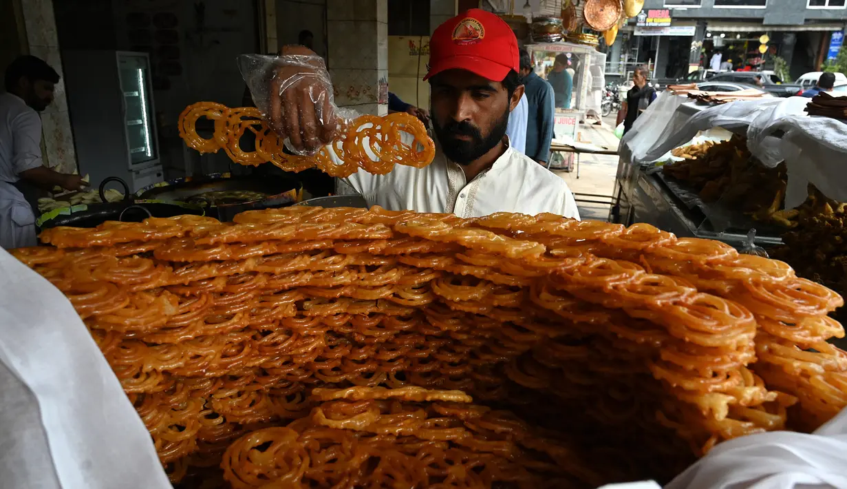 Seorang tukang roti menyiapkan makanan buka puasa Jalebi di sebuah toko di Islamabad, Pakistan, Kamis (23/3/2023). (Aamir QURESHI/AFP)