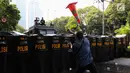 Perusuh melemparkan traffic cone ke arah polisi saat simulasi pengamanan Pemilu 2019 di depan Gedung KPU, Jakarta, Jumat (15/3). Simulasi diikuti personel gabungan dari TNI dan Polri. (Liputan6.com/JohanTallo)