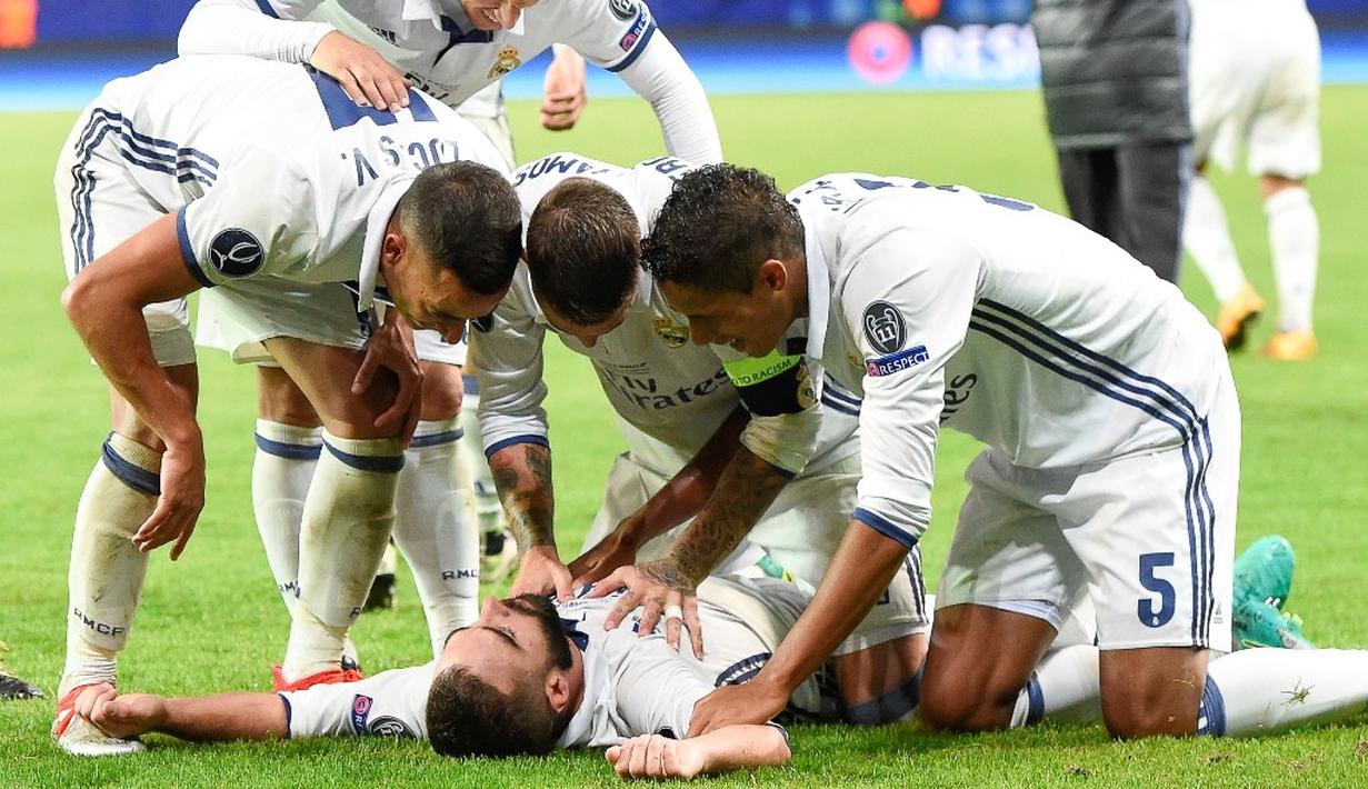 Pemain Real Madrid, Daniel Carvajal, disambut rekan-rekannya setelah mencetak gol penentu kemenangan atas Sevilla pada laga Piala Super Eropa 2016 di Stadion Lerkendal, Rabu (10/8/2016) dini hari WIB. (AFP/Jonathan Nackstrand)