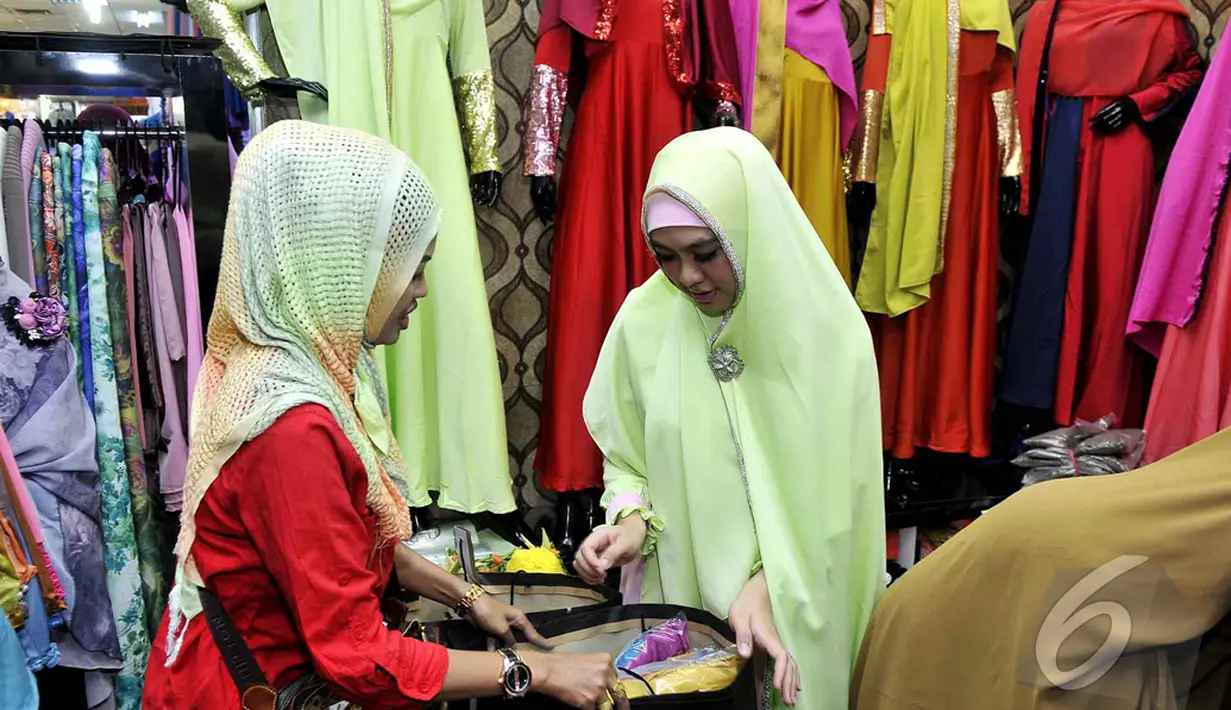  Oki Setiana Dewi melayani seorang pembeli yang datang ke toko busana muslim miliknya, Jakarta, Selasa (13/1/2015). (Liputan6.com/Faisal R Syam)